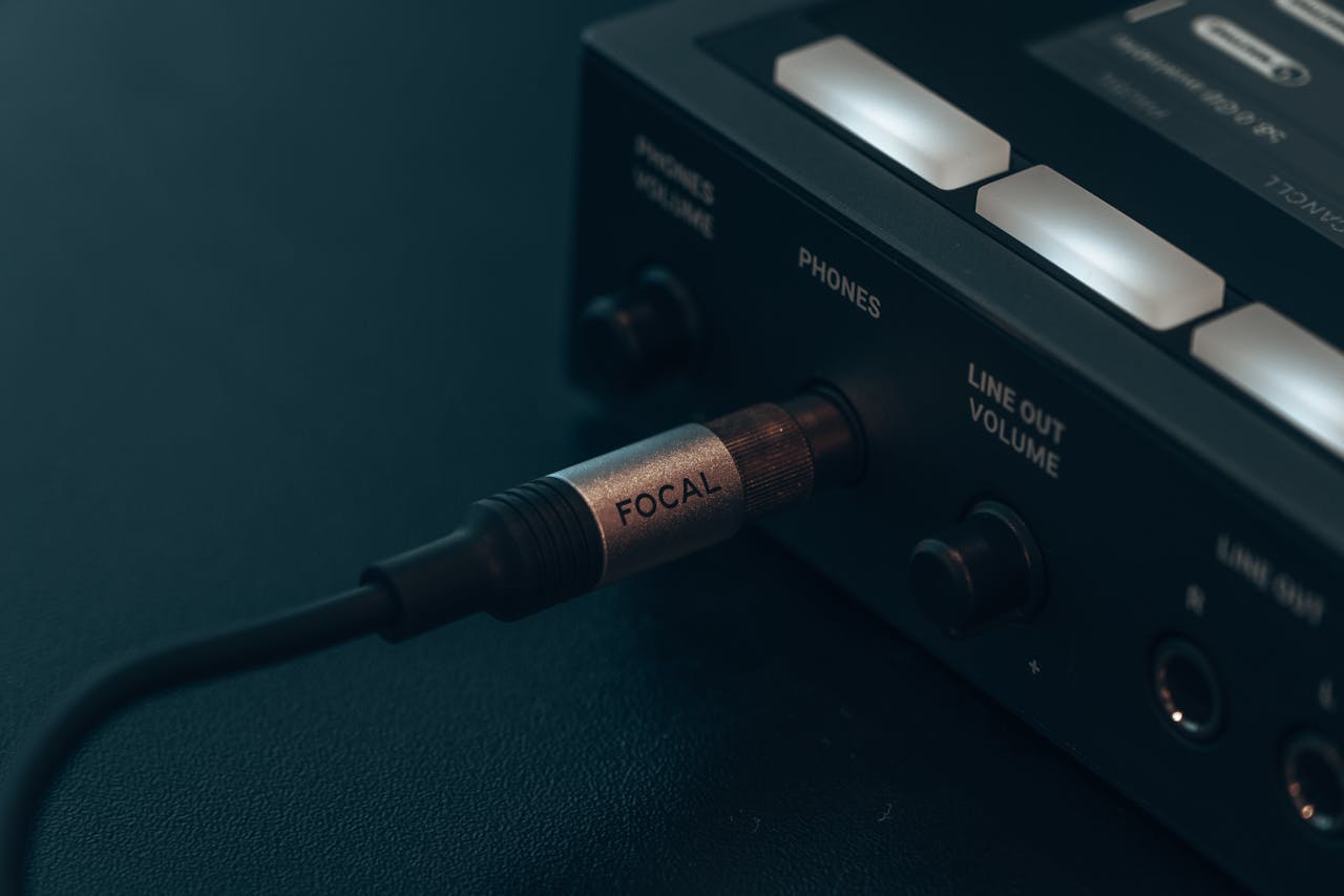 client-satisfaction-img Detailed view of audio cable connected to electronic device, capturing modern technology essence.